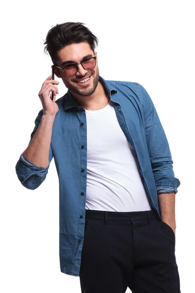 Hombre sosteniendo su mano en el bolsillo mientras habla por teléfono —  Fotos de Stock