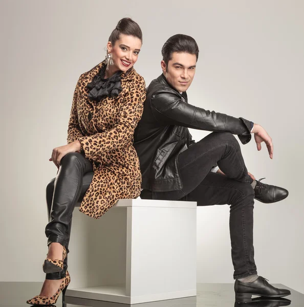 Side view of young fashion couple sitting — Stock Photo, Image