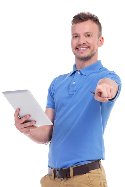 Homem jovem casual mantém seu tablet e pontos — Fotografia de Stock