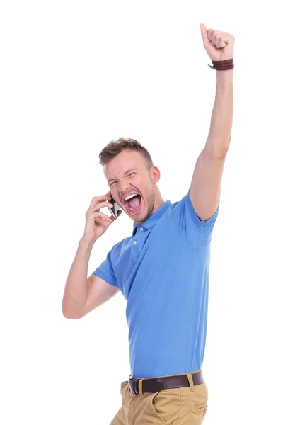 Lässiger junger Mann jubelt am Telefon — Stockfoto