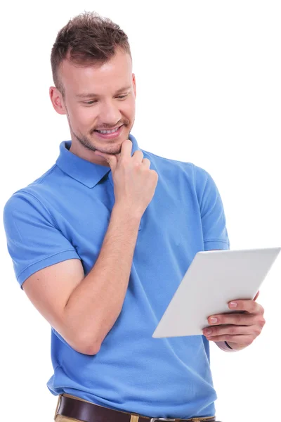 Lässiger junger Mann hält Tablet in der Hand und lächelt — Stockfoto