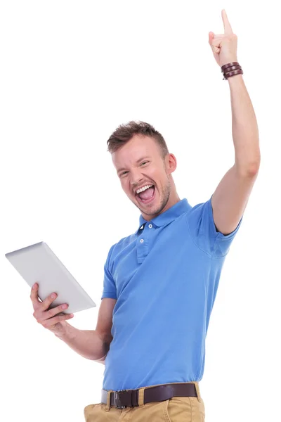 Casual young man with tablet cheers — Stock Photo, Image