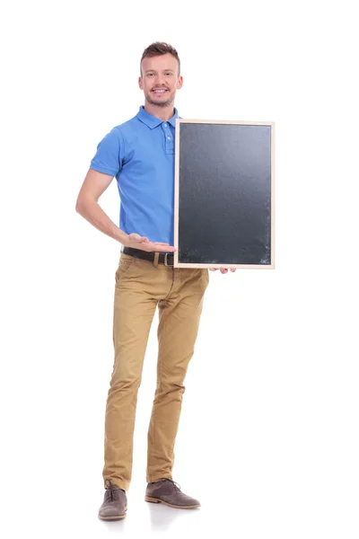 Casual young man presents blackboard — Stock Photo, Image