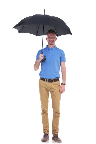 Jeune homme décontracté sous son parapluie — Photo