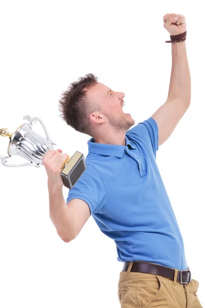 Casual young man shouts with trophy in hand Stock Photo