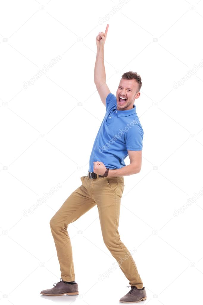 casual young man cheers and points up