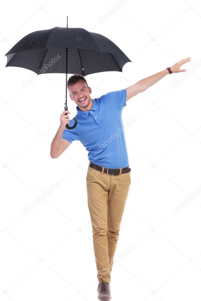 casual young man balancing with umbrella