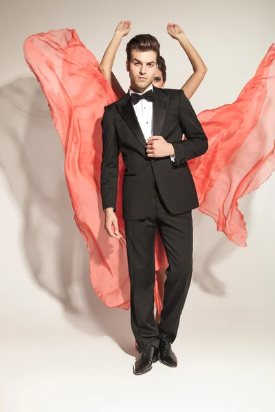 Man fixing tuxedo while his lover is fluttering her dress — Stock Photo, Image