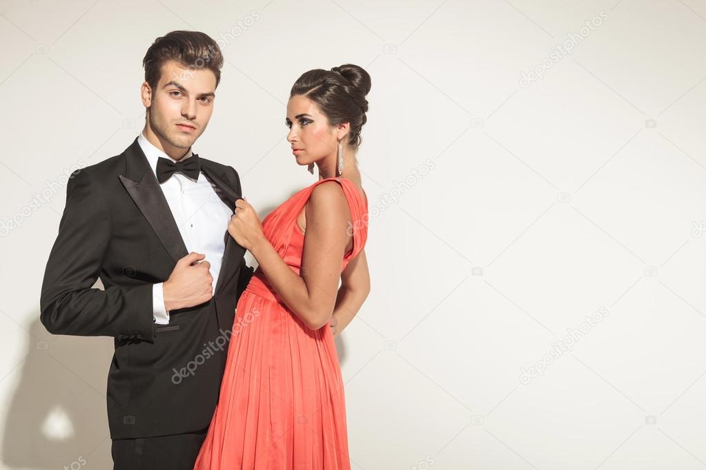 Elegant fashion woman pulling her lovers tuxedo 