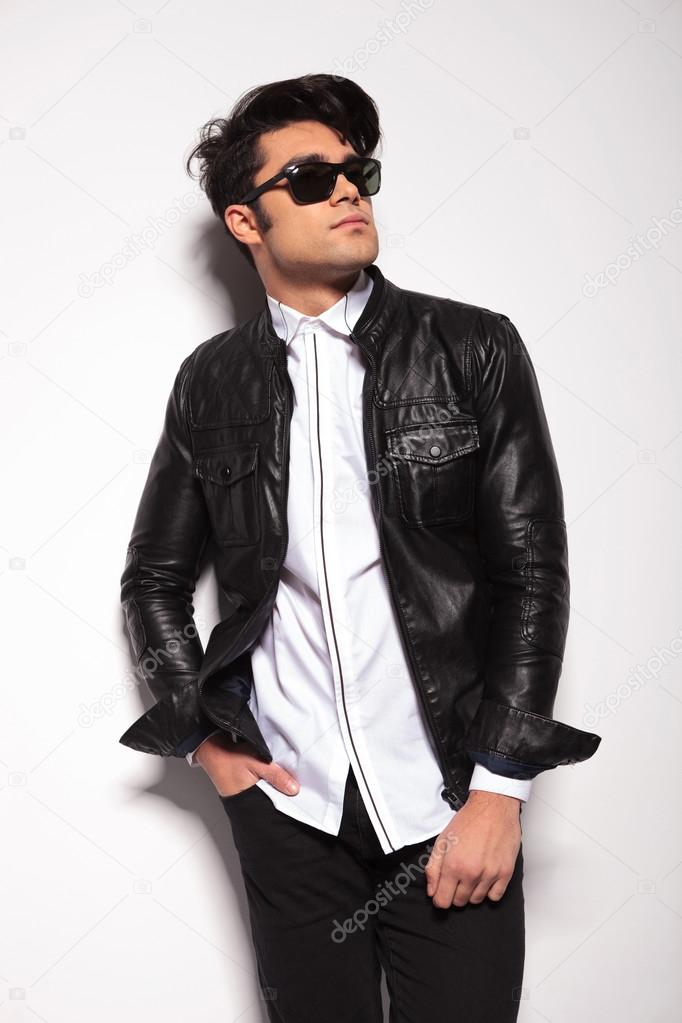 fashion man leaning on a white wall