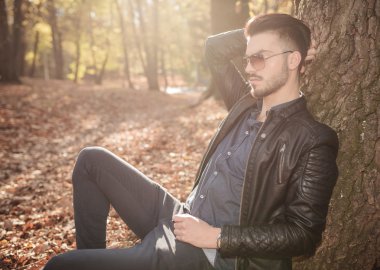  yakınındaki bir ağaç parkta oturan adam