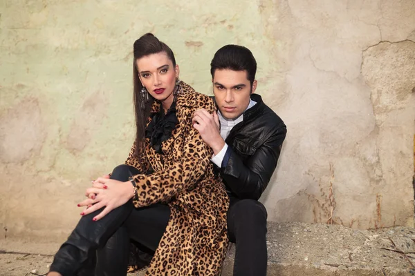 Fashion couple sitting and looking at the camera — Stock Photo, Image