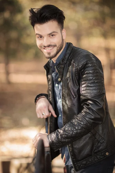 Jovem feliz homem casual apoiando-se em um corrimão . — Fotografia de Stock