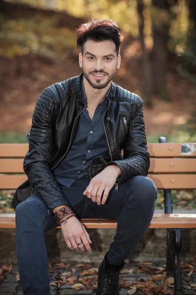 Casual young man sitting, resting his hands on his kness — Stock Photo, Image