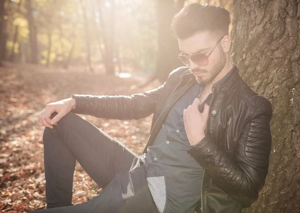 Lässiger junger Mann sitzt im Park — Stockfoto