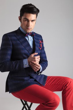 moda adam elleriyle oynarken oturuyor.