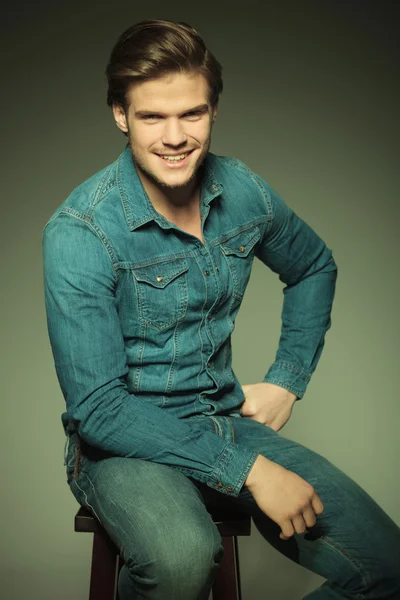 Homme de mode souriant assis sur un tabouret — Photo