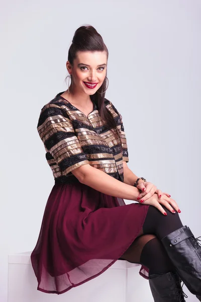Bella giovane donna di moda sorridente mentre seduto — Foto Stock