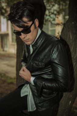 casual adam ağaca yaslanmış iken aşağı bakıyor