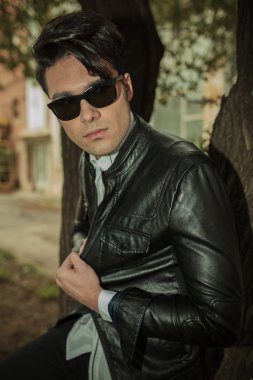 ağaca yaslanmış iken ceketini çekerek adam