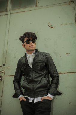 moda adam metal kapıya yaslanmış.