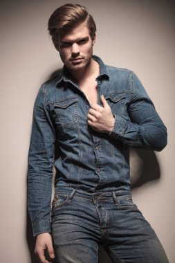 Çekici genç moda erkek gömleğini çekerek 