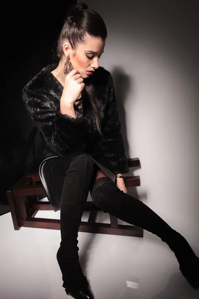 Young elegant woman sitting on a stool — Stock Photo, Image