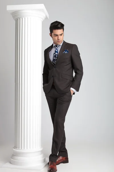 Full length picture of a young business man looking down