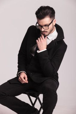 Çenesini için elini tutarak zarif iş adamı