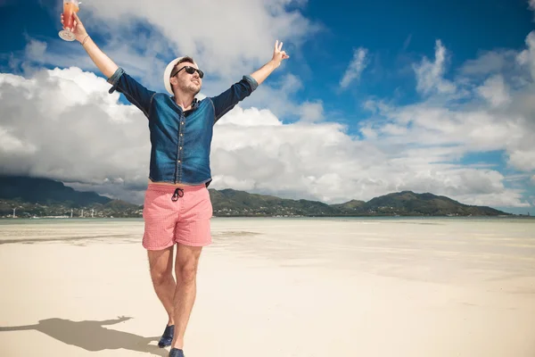 Muž na pláži drží oběma rukama ve vzduchu — Stock fotografie