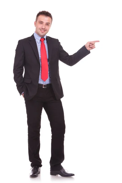 Young elegant business man pointing with one hand. Royalty Free Stock Images