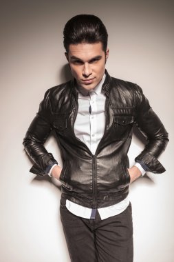 Genç casual adam beyaz duvara yaslanmış 
