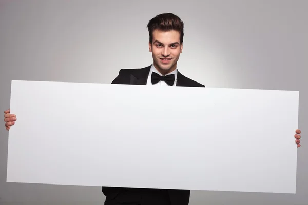 Elegante hombre de negocios sosteniendo un tablero en blanco — Foto de Stock