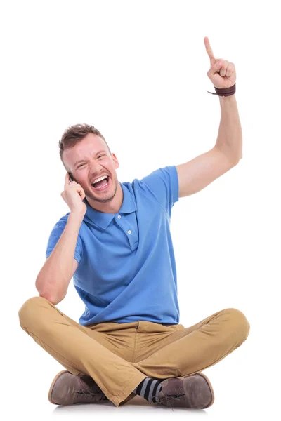 Jovem homem casual em seu telefone aponta para cima — Fotografia de Stock