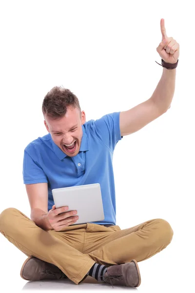 Jovem sentado aplaude com laptop na mão — Fotografia de Stock
