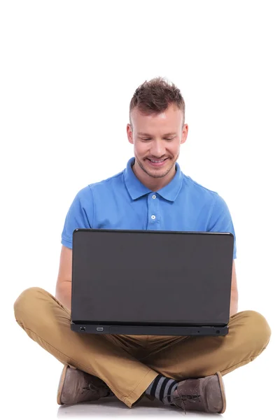 Zittende jonge man werkt op laptop — Stockfoto