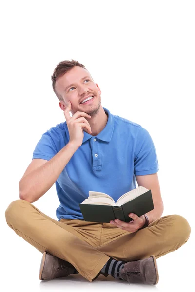 Junger Mann liest und träumt — Stockfoto