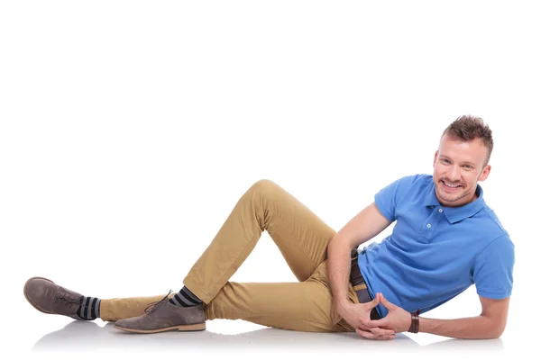 Happy young man lying on the floor — Stock Photo, Image