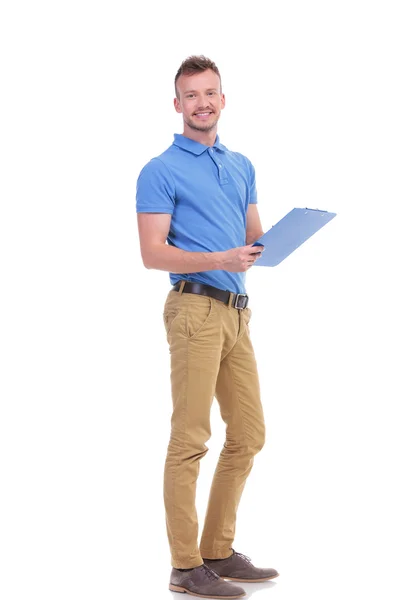 Young man takes notes on clipboard — Stock Photo, Image