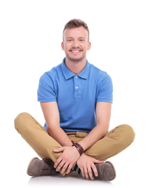 Seated young casual man smiles at camera — Stock Photo, Image