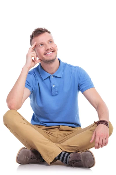 Seated young casual man pondering — Stock Photo, Image