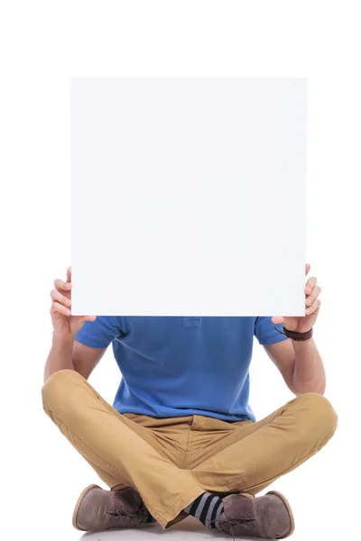 Sentado jovem casual homem com placa em branco — Fotografia de Stock