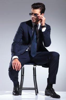 Bir taburede oturan çekici adam