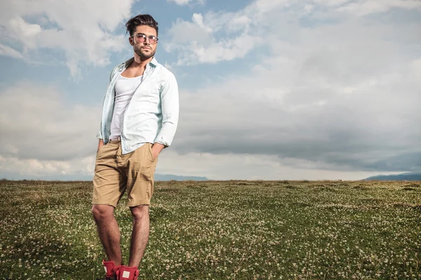 Young man posing in a field full of flowers — Stock Photo, Image