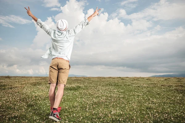 Visão traseira de um jovem homem de moda em um campo — Fotografia de Stock