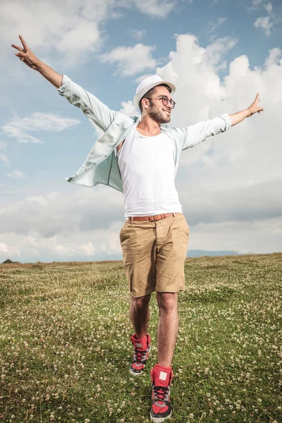 Joven hombre de la moda caminando sobre la hierba — Foto de Stock