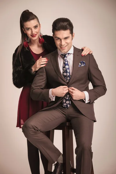 Man sitting on a stool while his girlfriend is standing — Stock Photo, Image