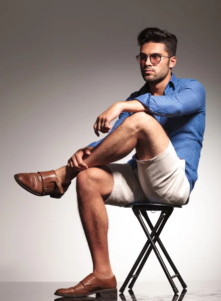 Smart casual young man sitting on a stool — Stock Photo, Image