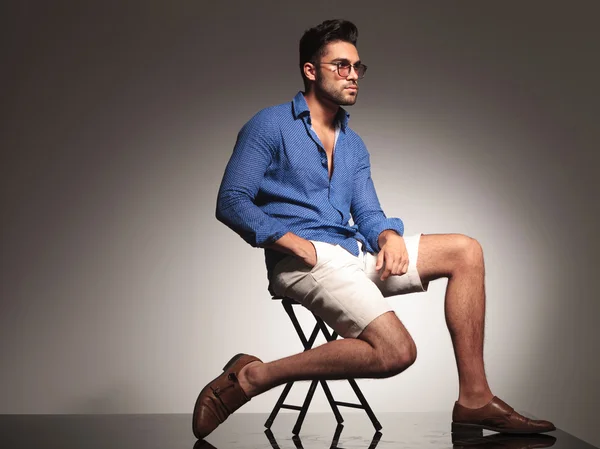 Attractive young fashion man sitting on a chair — Stock Photo, Image