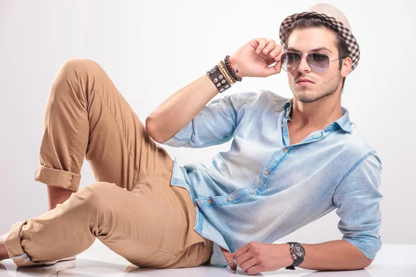 Attractive young man lying on studio background — Stock Photo, Image